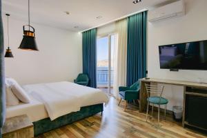 una camera d'albergo con un grande letto e una TV di Asi Rooftop Hotel a Sarandë