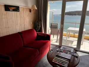 a living room with a red couch and a table at Une terrasse sur la mer in Crozon