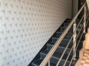 a staircase in a room with a white wall at Hotel Sai viraj palace in Shirdi