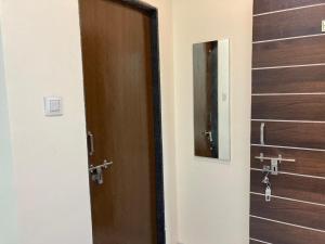 a bathroom with two brown doors and a mirror at Hotel Sai viraj palace in Shirdi