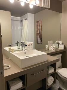 uma casa de banho com um lavatório branco e um WC. em Travelodge by Wyndham Drummondville em Drummondville