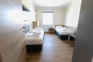 A bed or beds in a room at Das Reinisch Just Rooms