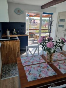 une cuisine avec une table et un vase de fleurs. dans l'établissement Domki na Wzgórzu Jastrzębia Góra Tupadły, à Jastrzębia Góra