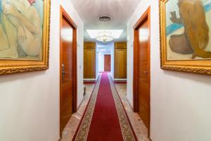 korytarz z obrazami na ścianach i czerwonym dywanem w obiekcie Hotel Riad Arruzafa w Kordobie