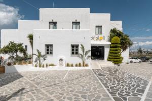 a white building with a courtyard in front of it at Anatoli Hotel in Naxos Chora