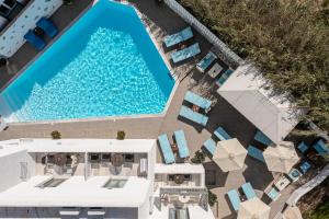 an overhead view of a swimming pool with chaise lounge chairs and a resort at Anatoli Hotel in Naxos Chora