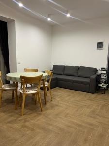 uma sala de estar com um sofá, uma mesa e cadeiras em Modern apartament em Mukachevo