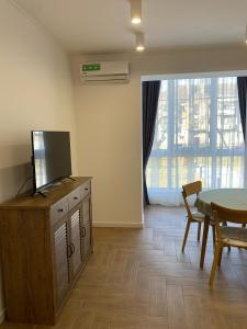 uma sala de estar com uma televisão numa cómoda com uma mesa em Modern apartament em Mukachevo