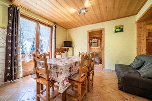 una sala da pranzo con tavolo, sedie e divano di Apt Chénives 2 - Morzine a Morzine