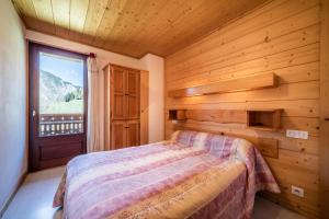 una camera con un letto e una grande finestra di Apt Chénives 2 - Morzine a Morzine