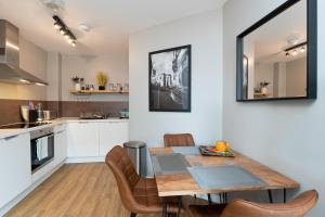 cocina y comedor con mesa de madera y sillas en High Street Town House, en Mánchester