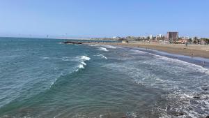 Blick auf den Strand mit Menschen im Wasser in der Unterkunft SAN AGUSTIN SEAVIEW BLUE APARTMENT in Maspalomas