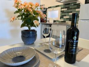 uma mesa com uma garrafa de vinho e dois copos em Tender Suite em Corralejo