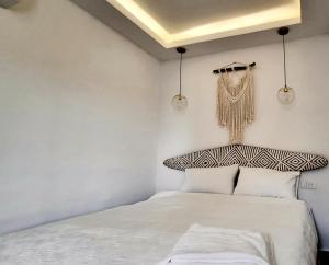 een witte slaapkamer met een bed en 2 verlichting bij Luxurious and cosy studio in Abidjan