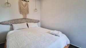 een kleine slaapkamer met een bed met witte lakens en kussens bij Luxurious and cosy studio in Abidjan