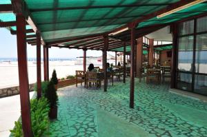 a patio with tables and chairs on the beach at Hotel Lido in Mamaia