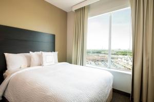 Residence Inn by Marriott Houston Medical Center/NRG Park في هيوستن: غرفة نوم بسرير كبير ونافذة كبيرة