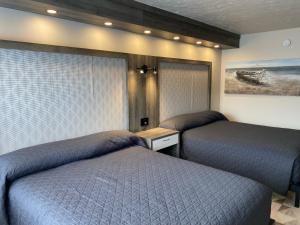 um quarto com duas camas e um quadro na parede em Travelodge by Wyndham Drummondville em Drummondville