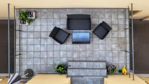 a room with a tiled wall with two monitors on it at Hotel Kindler 2,0 Self-Check-In in Leoben