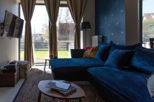 a living room with a blue couch and a table at BlueWater Apartment in Mikołajki