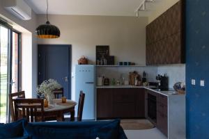 a kitchen with a table and a blue wall at BlueWater Apartment in Mikołajki