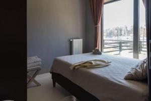 a bedroom with a bed and a large window at BlueWater Apartment in Mikołajki