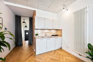 eine Küche mit weißen Schränken und Holzböden in der Unterkunft Lit Living - Luxus Loft - Box Spring - Air Con - BBQ - Panorama in Mannheim