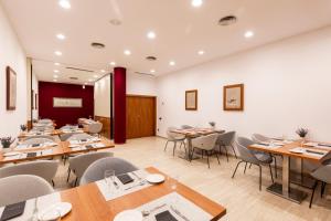 comedor con mesas y sillas de madera en Catalonia Gran Hotel Verdi, en Sabadell