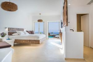 een slaapkamer met een bed en uitzicht op de oceaan bij KLIDON Dreamy Living Suites in Mykonos-stad