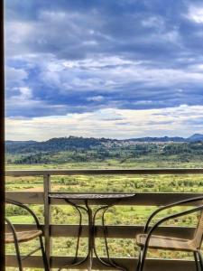 einen Tisch und Stühle auf einem Balkon mit Aussicht in der Unterkunft Great Escape Olympia in Olympia