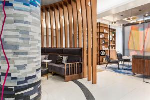 een lobby met een bank en een tafel en stoelen bij Le Méridien New York, Fifth Avenue in New York