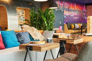 ein Wohnzimmer mit einem Sofa und einem Tisch in der Unterkunft Moxy Paris Charles de Gaulle Airport in Roissy-en-France