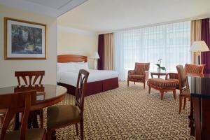 une chambre d'hôtel avec un lit, une table et des chaises dans l'établissement Leipzig Marriott Hotel, à Leipzig