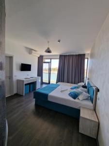 a bedroom with a bed and a desk and a television at Hotel H pe plaja Belona in Eforie Nord