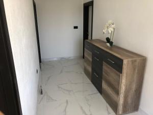 een kamer met een dressoir met een vaas met bloemen erop bij Apartman M&D in Neum