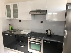 een keuken met witte kasten en een fornuis met oven bij Apartman M&D in Neum