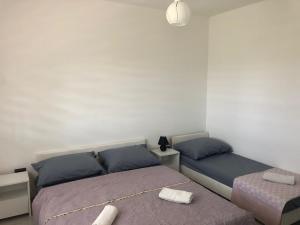 een slaapkamer met 2 bedden en een lamp bij Apartman M&D in Neum