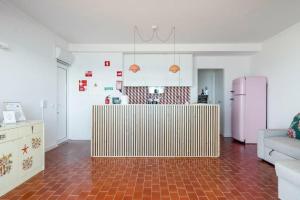 uma sala de estar com uma cozinha com um frigorífico rosa em Ria Beach House em Faro