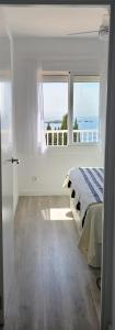 a bedroom with a bed and a large window at Apartamento Canyelles playa in Roses