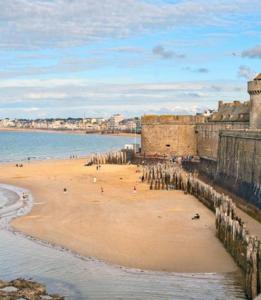 una playa con un grupo de personas en la arena en Alba hotel, en Saint-Malo