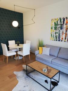 uma sala de estar com um sofá e uma mesa em Suite 51 Appartamento con terrazzo a 50 mt dal lago - Private Parking em Arona