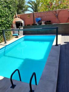 - une piscine d'eau bleue et un grill dans l'établissement Beach House São Pedro, à São Pedro do Estoril