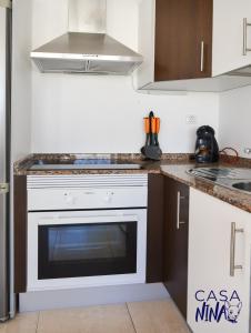 a kitchen with a white oven in a kitchen at B-Rent Los Delfines Casa Nina in Corralejo