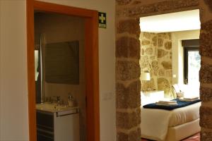 La salle de bains est pourvue d'une chambre avec un lit et un lavabo. dans l'établissement Vila de Campos - Gerês, à Vieira do Minho