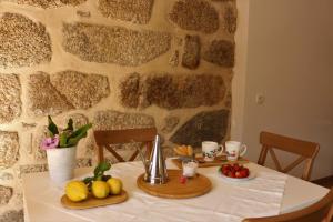 - une table avec des fruits et un mur en pierre dans l'établissement Vila de Campos - Gerês, à Vieira do Minho