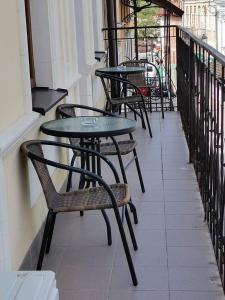 a row of tables and chairs on a balcony at Апартаменти в Старому Місті Sweet House in Kamianets-Podilskyi