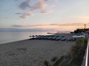 plaża z parasolami i krzesłami oraz ocean w obiekcie N G Luxury Apartments at Nea Kallikrateia No 2 w miejscowości Nea Kallikratia