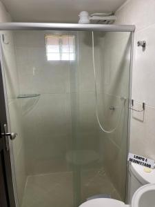 a glass shower in a bathroom with a toilet at Pousada Beijos y Abraços in Natal