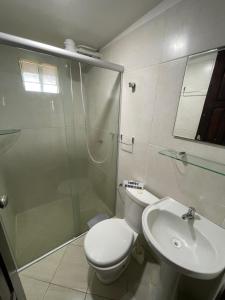 a bathroom with a shower and a toilet and a sink at Pousada Beijos y Abraços in Natal