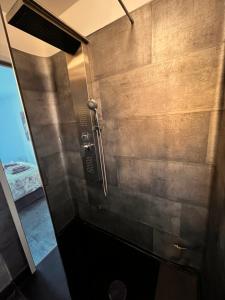 a shower in a bathroom with a concrete wall at Une terrasse sur la mer in Crozon